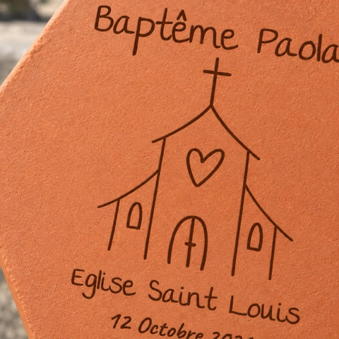 Tomette personnalisée Baptême - Eglise, posée dans les mains d’une enfant, avec église et lavande en arrière-plan — vue rapprochée du motif