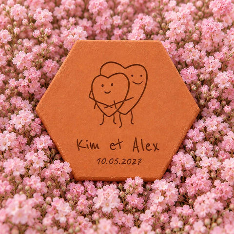 Carreau décoratif Coeurs amoureux en terre cuite, posé sur des fleurs roses pastel. — vue en situation