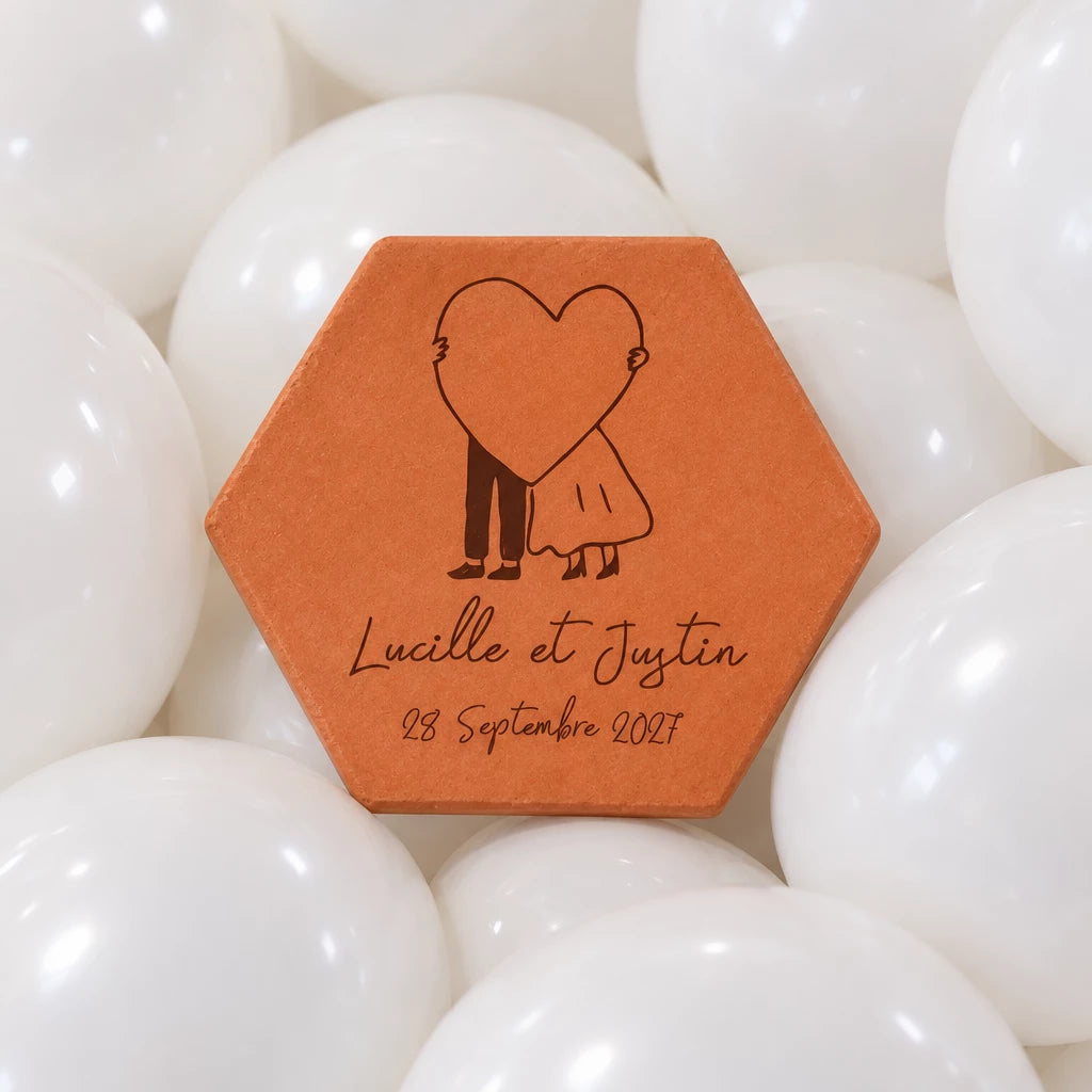 Pieza hexagonal de terracota «Gran corazón» sobre un lecho de globos blancos.