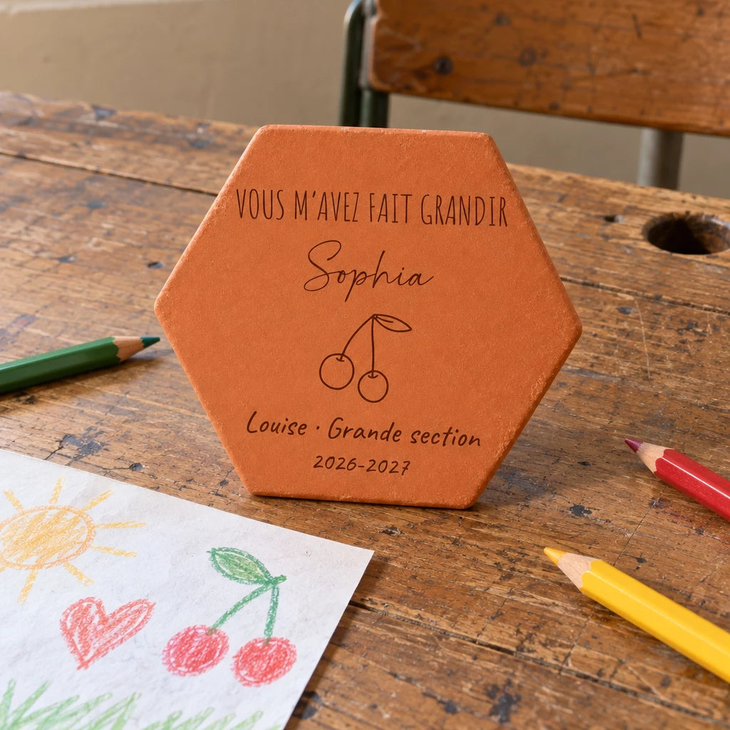 Tomette personnalisée Merci maîtresse, motif cerises, sur vieux bureau d’écolier avec dessin et crayons — vue en situation