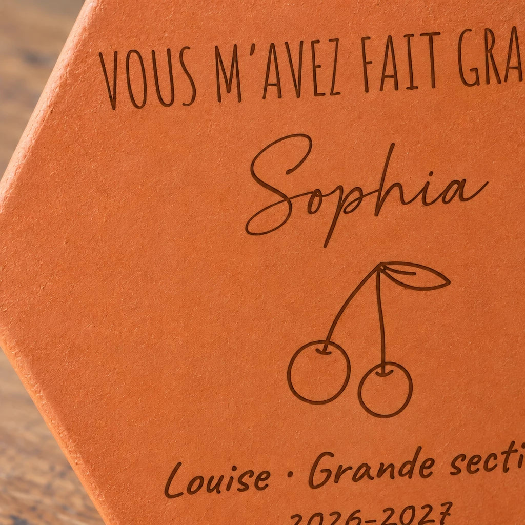 Tomette personnalisée Merci maîtresse, motif cerises, sur vieux bureau d’écolier avec dessin et crayons — vue rapprochée du motif