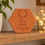 Azulejo decorativo de Navidad en terracota, motivo Noël en famille con corona y corazón, inscripción personalizada. — vista en ambiente