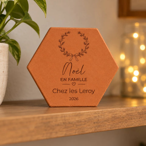 Azulejo decorativo de Navidad en terracota, motivo Noël en famille con corona y corazón, inscripción personalizada. — vista en ambiente