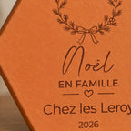 Azulejo decorativo de Navidad en terracota, motivo Noël en famille con corona y corazón, inscripción personalizada. — vista de cerca del motivo