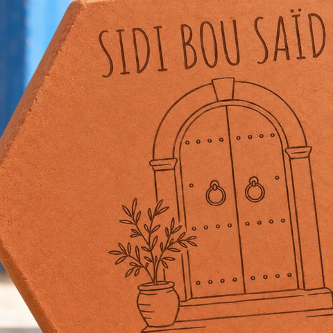 Carreau en terre cuite avec la porte de Sidi Bou Saïd et un village tunisien en arrière-plan — vue rapprochée du motif